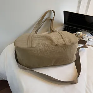 Detailed texture of khaki nylon tote bag with laptop and silver headphones