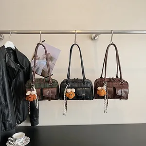 Detail of vintage plaid Boston bags with faux leather pockets and cute bear charms
