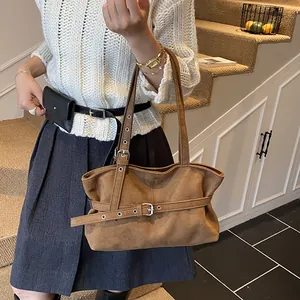 Detail of vintage brown suede tote bag with adjustable straps and metallic hardware