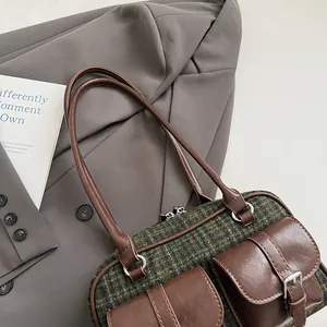 Macro shot of retro plaid Boston bag with leather details and twin front buckle pockets
