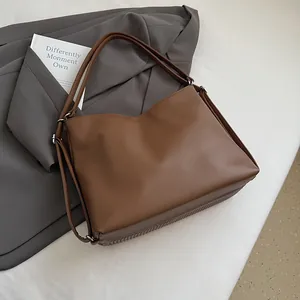 Close-up of a large dark brown tote bag in pebbled leather with unique vertical striped base