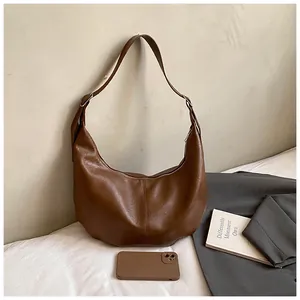 Détail du sac hobo rétro marron avec fermeture éclair et surpiqûres verticales