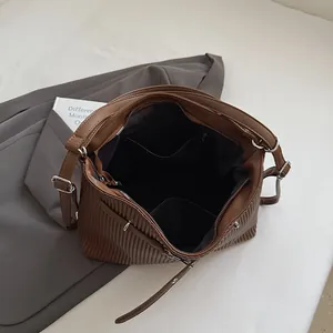 Detailed interior of a brown pleated PU leather bag showing large capacity and pockets