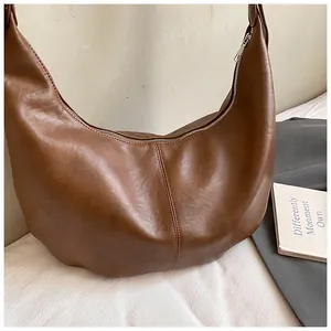 Détail du sac hobo croissant marron avec couture verticale et fermeture éclair métallique