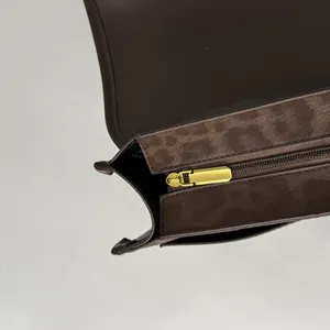 Détail intérieur d'un sac en cuir marron avec doublure en daim et zip doré mat