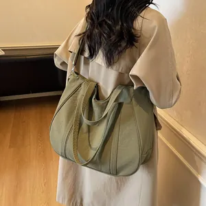 Detail of green canvas tote bag with adjustable shoulder strap and spacious interior