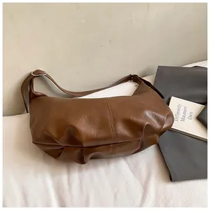 Détail du sac lune marron foncé montrant la texture plissée en cuir synthétique chic