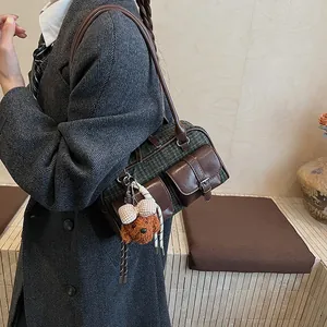 Close-up of retro plaid Boston bag with plush bear charm and faux leather trim detail