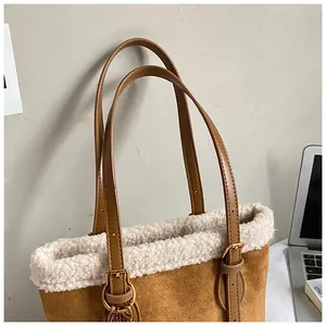 Detail einer braunen Wildledertasche mit weißem Lammfellbesatz und verstellbarem Gurt