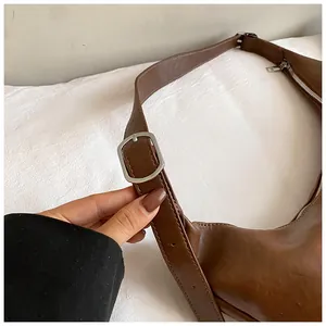 Gros plan du sac en cuir marron avec boucle en métal argenté et fermeture éclair lisse
