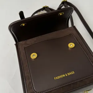 Gros plan du sac à dos en cuir marron avec boucles aimantées dorées et logo de mode