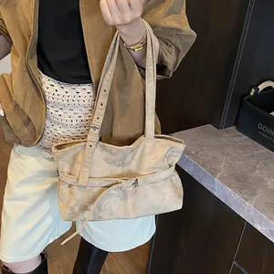 Detail of suede tote bag featuring adjustable metal buckles and retro shoulder strap