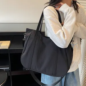 Detail of a large black tote bag with adjustable straps for daily commuting and storage