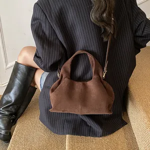 Brown suede hobo bag with dual straps shown in a minimalist autumn fashion style