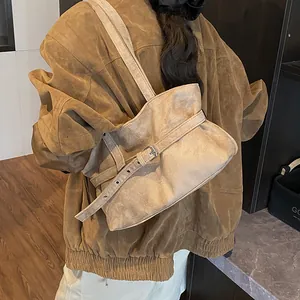 Detailed view of khaki suede tote bag with decorative silver buckle belt on shoulder