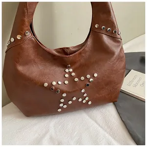 Macro detail of brown textured leather bag with metallic silver star-shaped rivet decor