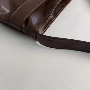 Close-up of precise stitching and premium dark brown faux leather texture on tote bag