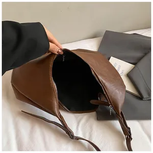 Vue détaillée de l'intérieur d'un sac bandoulière en similicuir marron avec fermeture éclair