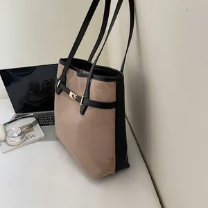 Détail du sac cabas rétro en daim et cuir avec boucle dorée et fines bandoulières