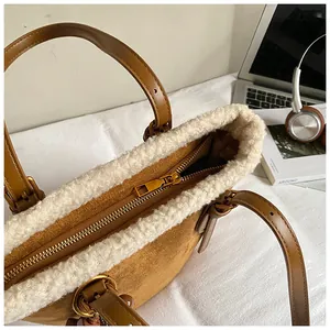 Detail einer braunen Wildledertasche mit weißem Kunstpelzbesatz und goldenem Reißverschluss