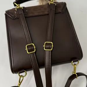 Détails du sac à dos marron foncé avec boucles dorées et bretelles réglables