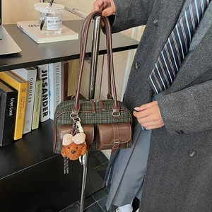 Detail of vintage plaid Boston bag with leather pockets and cute dog charm in lifestyle setting