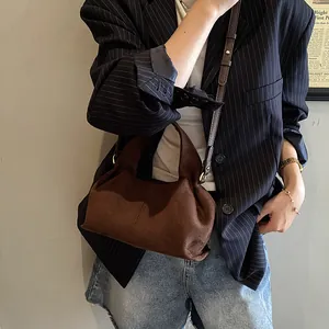 Brown faux suede handbag paired with a striped blazer for a retro autumn fashion look