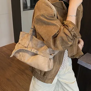 Detail view of vintage brown suede tote bag with stylish belt buckle and adjustable strap