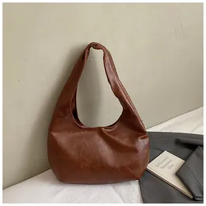 Detail view of dark brown punk style underarm bag with vintage wrinkled PU leather texture