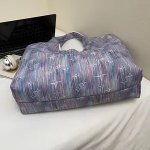 Detailed macro view of star pattern tote bag on desk with laptop and headphones