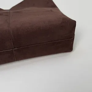 Détail macro du sac cabas en daim marron foncé montrant les coutures et la structure