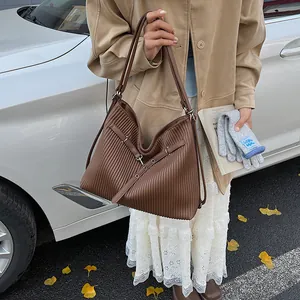 Detail of dark brown pleated leather shoulder bag with buckle and large capacity