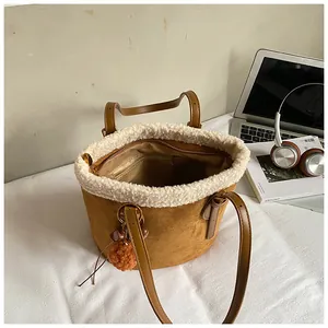 Innendetails der braunen Wildleder-Beuteltasche mit weißem Lammfellbesatz und Reißverschlussfach