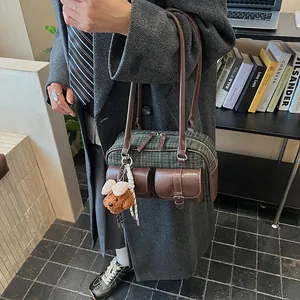 Detail of vintage green plaid tweed boston bag with brown leather trim and bear charm
