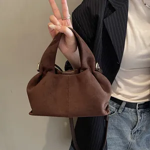 Close-up of the vintage dark brown suede handbag featuring textured pleats and soft finish