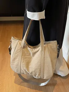 Large beige nylon tote bag with dual handles and adjustable strap for women