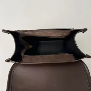 Vue intérieure du sac à dos en cuir marron avec compartiment principal et poche zippée