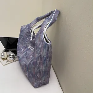 Close-up of canvas tote bag with blue-purple gradient stripes and star pattern detail