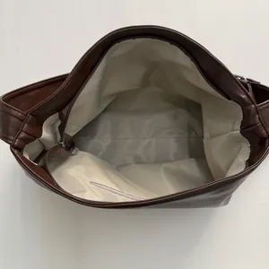Top view of large brown tote bag showing herringbone lining and internal zip pocket