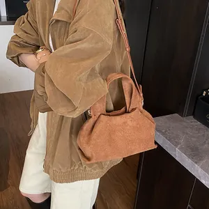 Detail of caramel suede cloud bag with soft pleats and adjustable shoulder strap