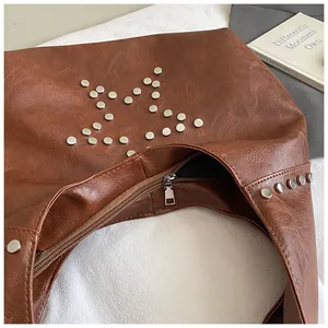 Close-up of vintage brown PU leather shoulder bag with silver star rivet detailing
