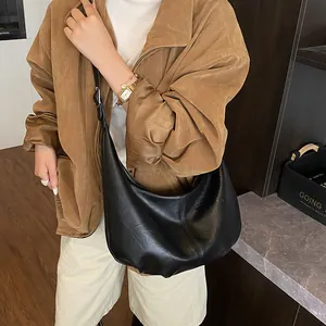 Gros plan du sac hobo noir avec texture cuir fine et boucle métallique
