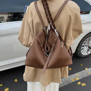 Close-up of deep brown pleated texture on a large backpack with metal buckle detail