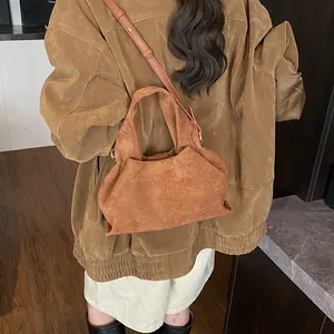 Retro brown suede handbag with soft pleats shown worn by a model in casual setting