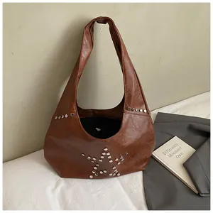 Detailed side view of brown faux leather hobo bag with silver star-shaped rivet studs