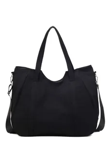 Minimalist black canvas tote bag with double handles and adjustable crossbody strap