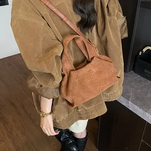Close-up detail of the brown suede hobo bag showing texture and stitching details