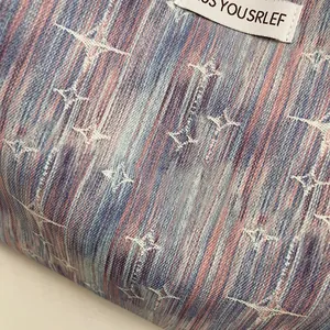 Detailed close-up of blue and pink tie-dye denim fabric with white star pattern texture