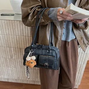 Close-up of retro plaid Boston bag with leather pockets and a cute puppy keychain