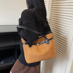 Détail du grand sac cabas en daim marron vintage avec anses en cuir noir et boucle en métal